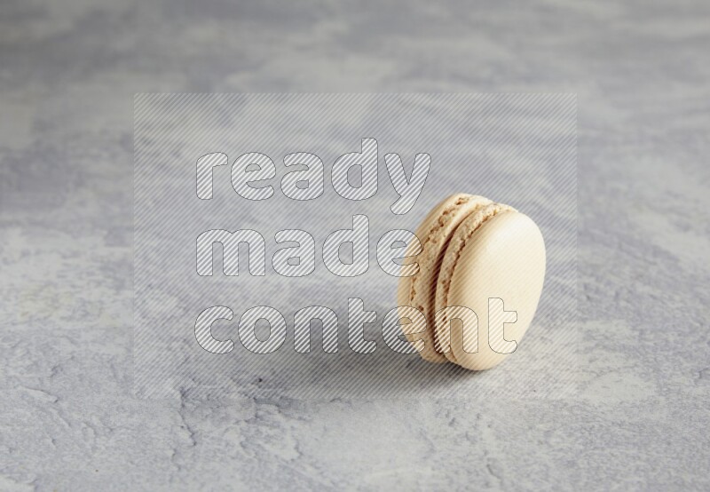 45º Shot of white marbleCaramel fleur de sel macaron on white  marble background