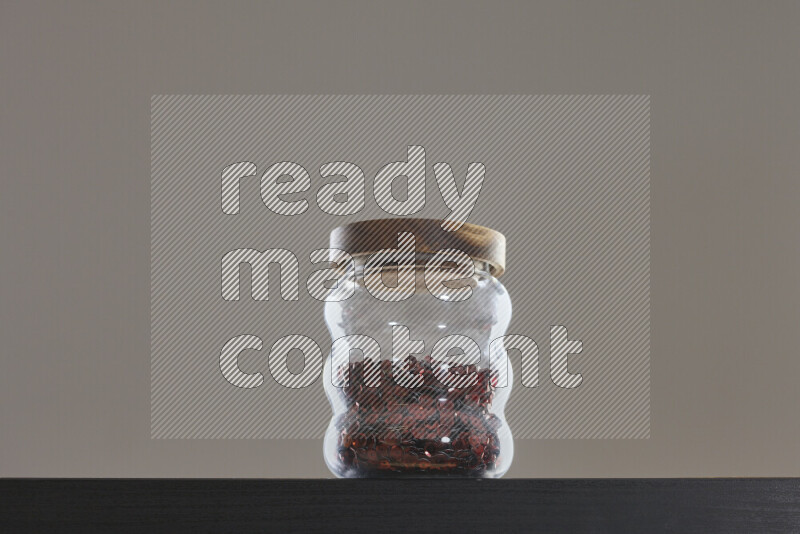 Sequins in a glass jar on black background