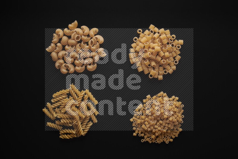 Different pasta types in bunches on black background