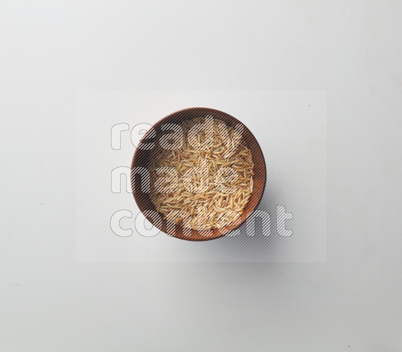 Top-view shot of long grain brown rice in a container on white background