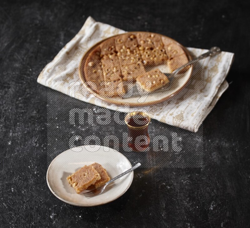 Basbousa with tea in a dark setup