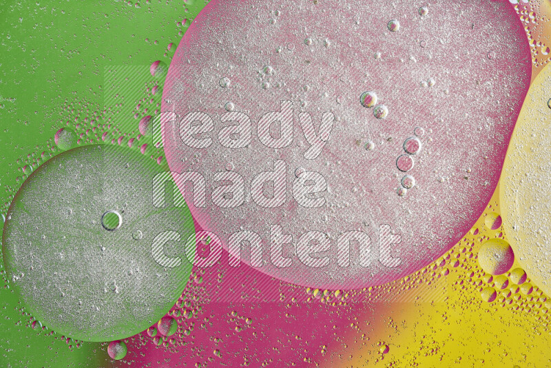 Close-ups of abstract oil bubbles on water surface in shades of yellow, green and pink