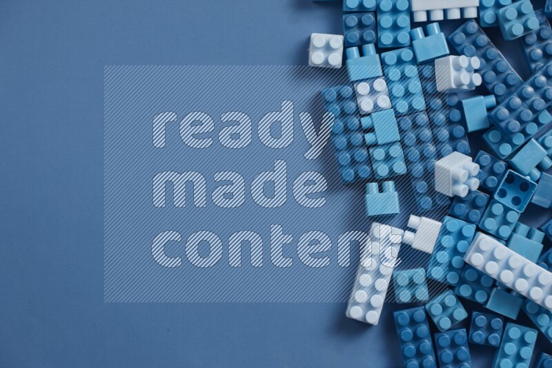 Blue plastic building blocks on blue background (kids toys)