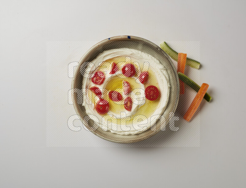 Lebnah garnished with cherry tomato in a grey pottery plate on a white background
