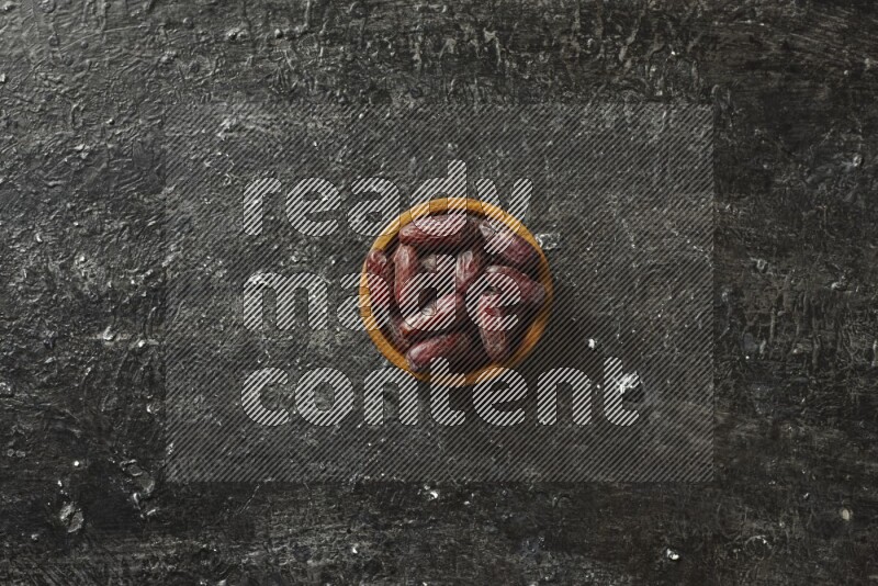 تمر في أطباق خشبية علي خلفية سوداء