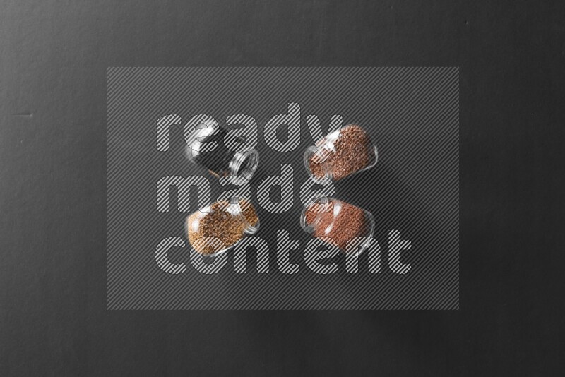 حبة البركة و حبوب الخردل وحبوب الكتان وحب الرشاد في أوعية زجاجية علي خلفية سوداء