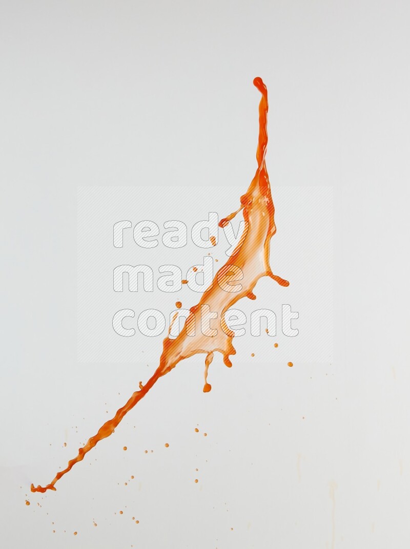 Orange liquid splash and drops on white background