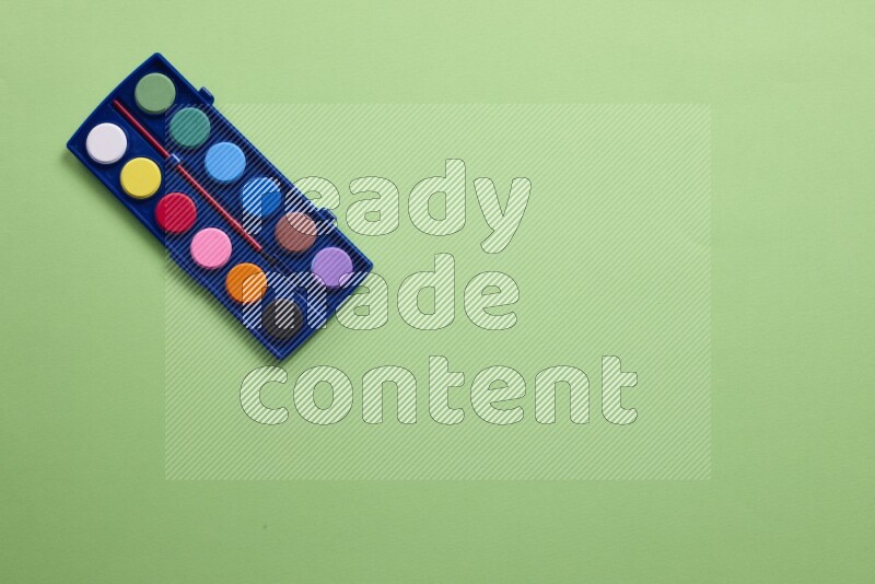 Watercolor paint set on green background