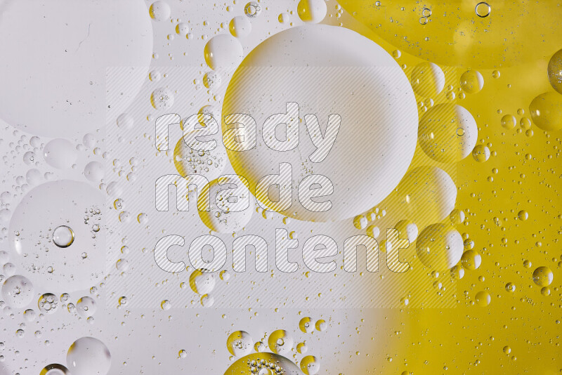 Close-ups of abstract oil bubbles on water surface in shades of white and yellow