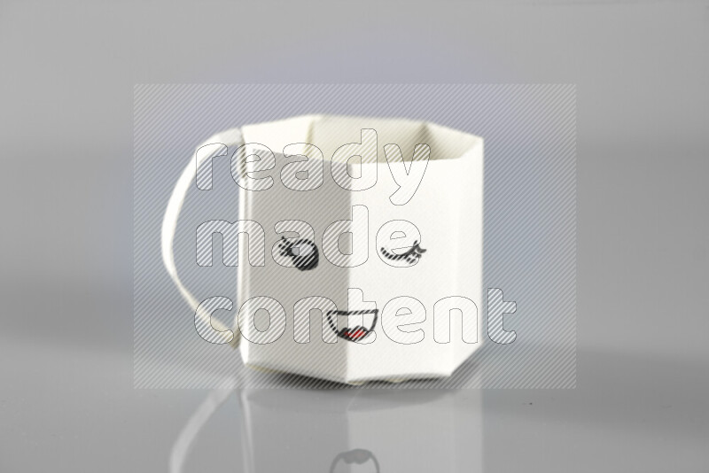Origami cup on grey background