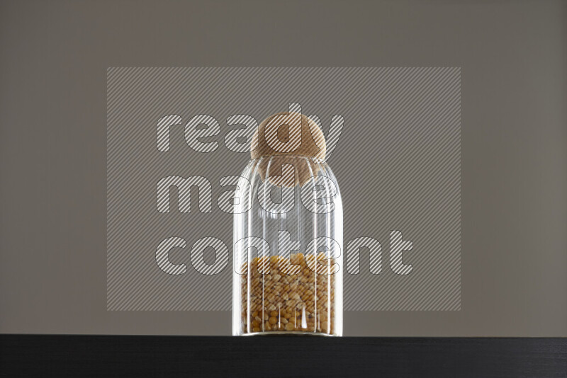 Pop corn in a glass jar on black background