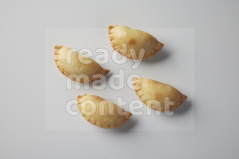 Four fried sambosa from a top angle on a white background