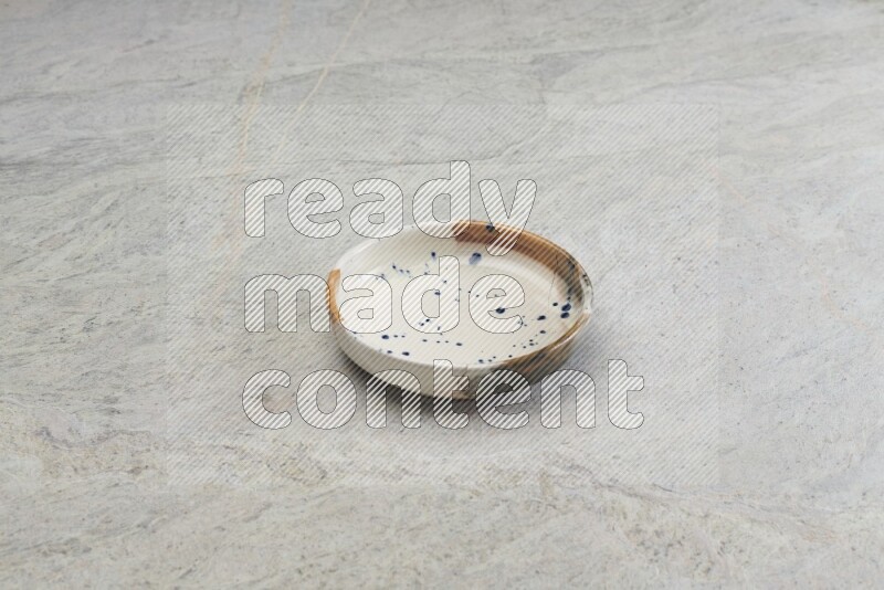 A multicolored pottery bowl on grey marble background