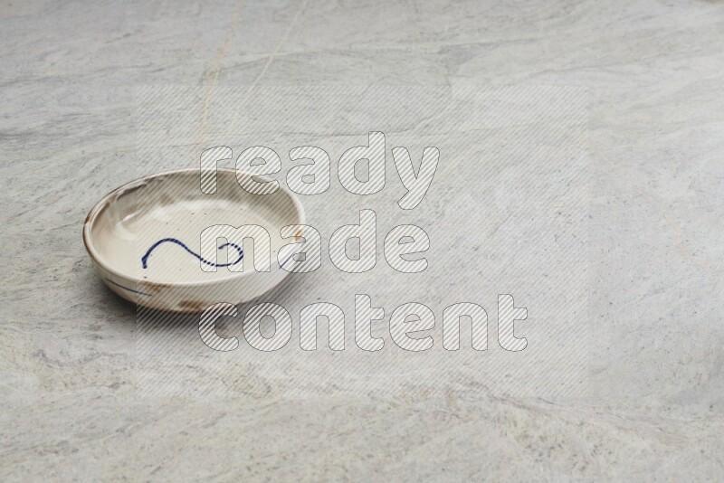 A multicolored pottery bowl on grey marble background