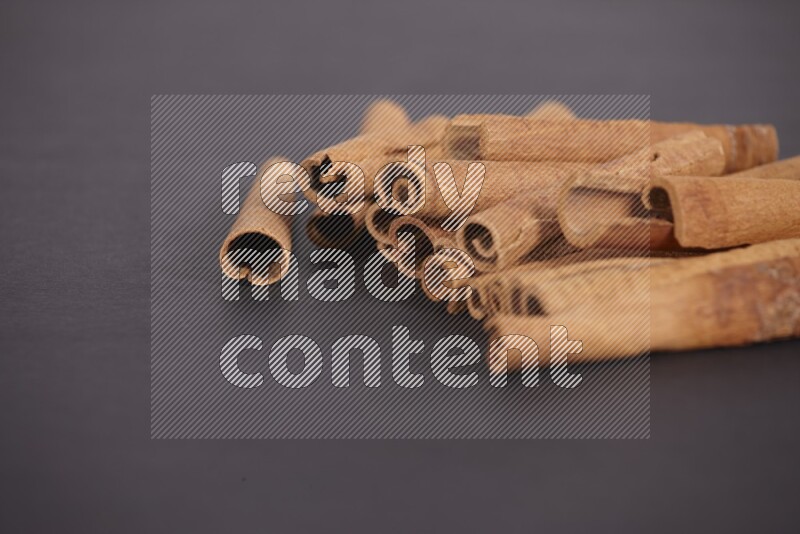 Cinnamon sticks stacked on black flooring