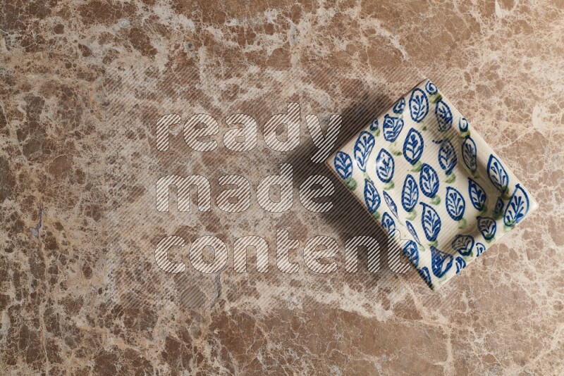 A decorative pottery plate on beige marble background