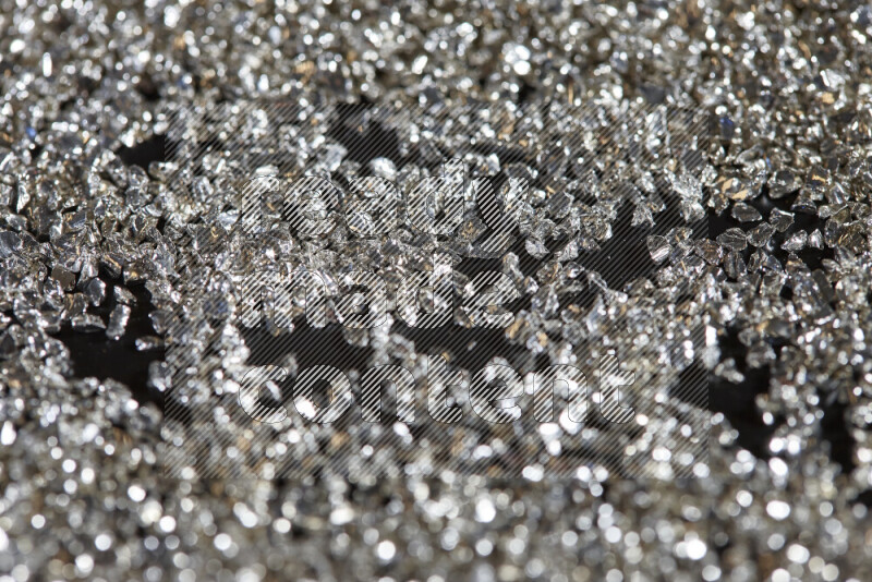 قطع زجاجية فضية لامعة متناثرة على خلفية سوداء