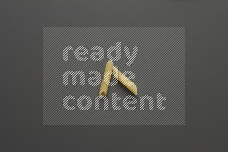 Mini penne pasta on grey background
