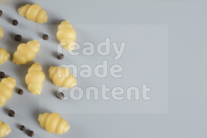 معكرونة مع مكونات متنوعة من الطماطم والثوم والبصل والفلفل الأحمر والفلفل الأسود والفلفل الأبيض وأوراق الغار وإكليل الجبل والهيل و مشروم على خلفية زرقاء فاتحة