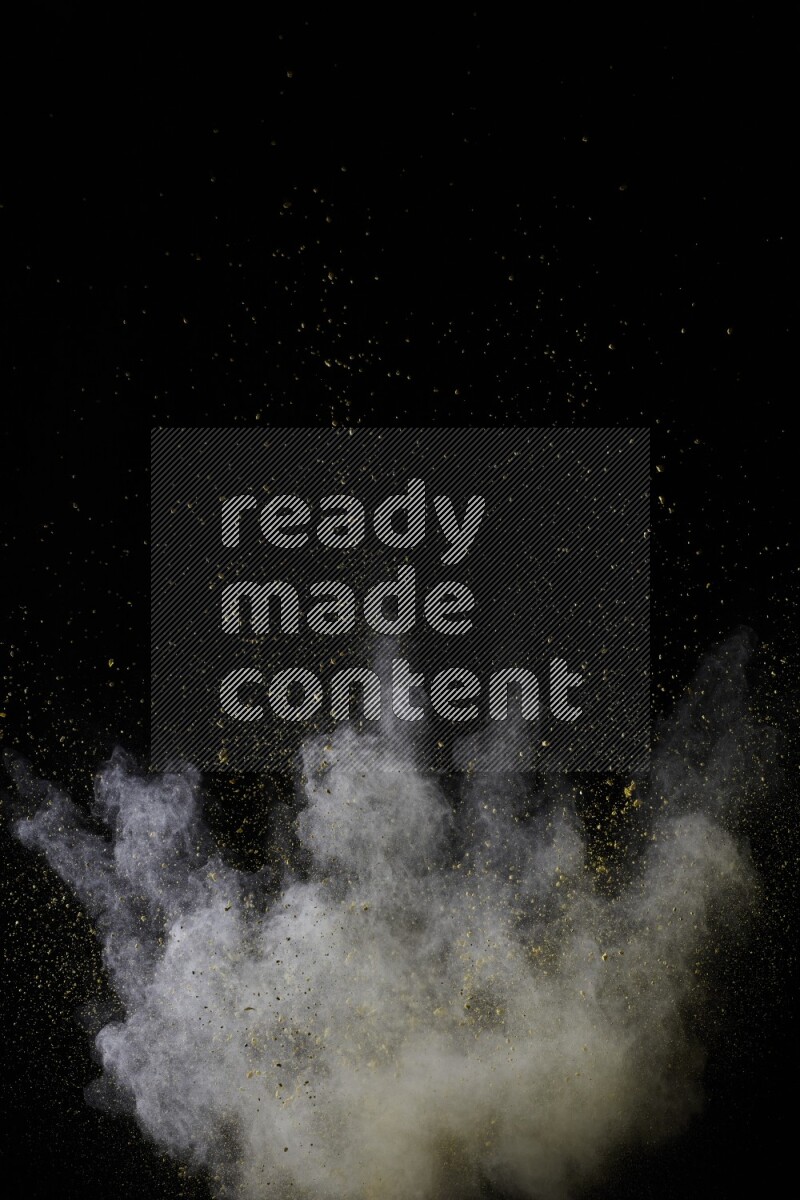 A side view of yellow powder explosion on black background