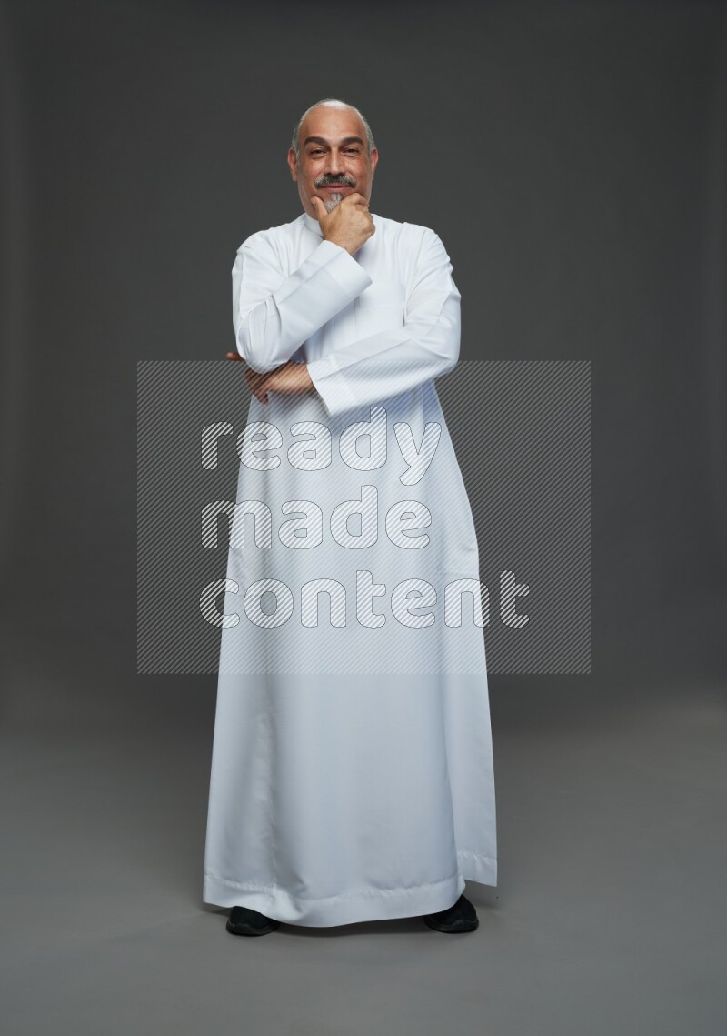 Saudi man without shomag Standing Interacting with the camera on gray background