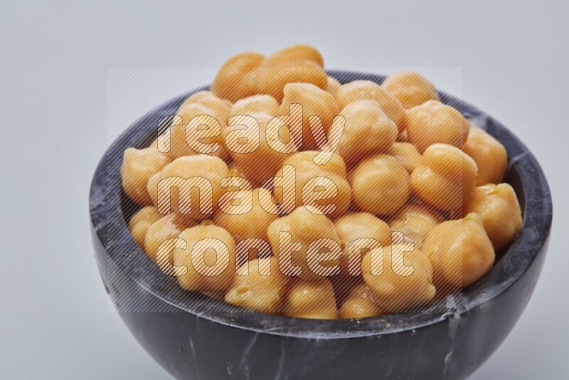Close up of a boiled chickpeas in a container on white background