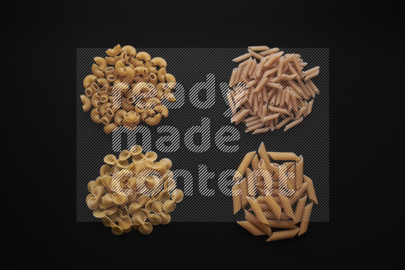Different pasta types in bunches on black background