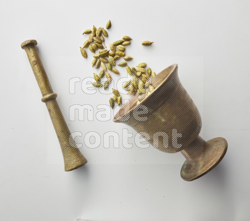Top-view shot of Cardamon in herbs crusher on white background