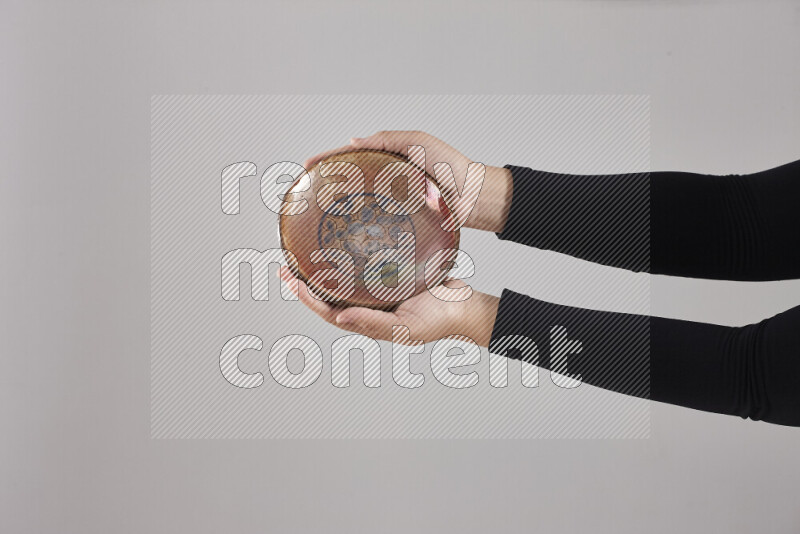 A woman in black abaya holding different pottery essentials in different positions