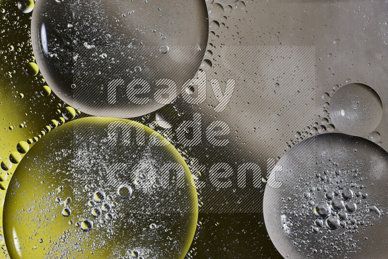 Close-ups of abstract oil bubbles on water surface in shades of brown, black and yellow