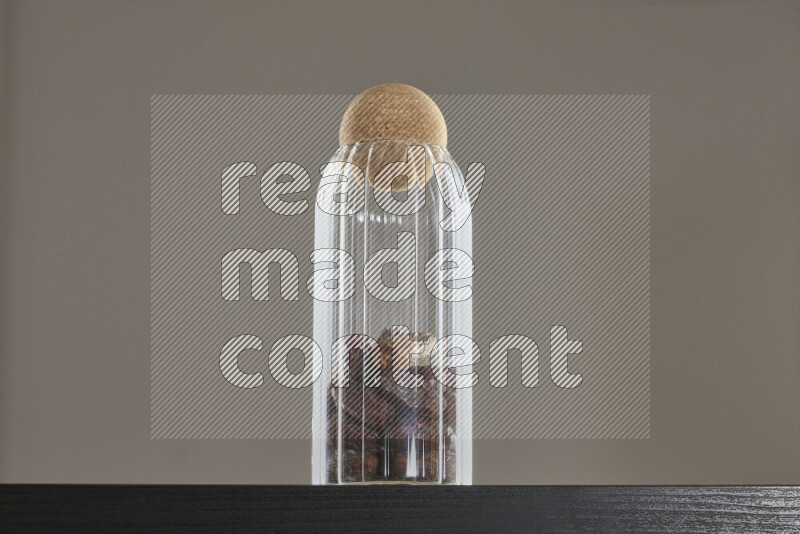 تمر في وعاء زجاجي على خلفية سوداء