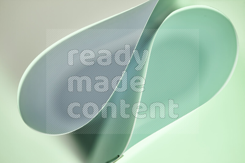 An abstract art of paper folded into smooth curves in white and green gradients