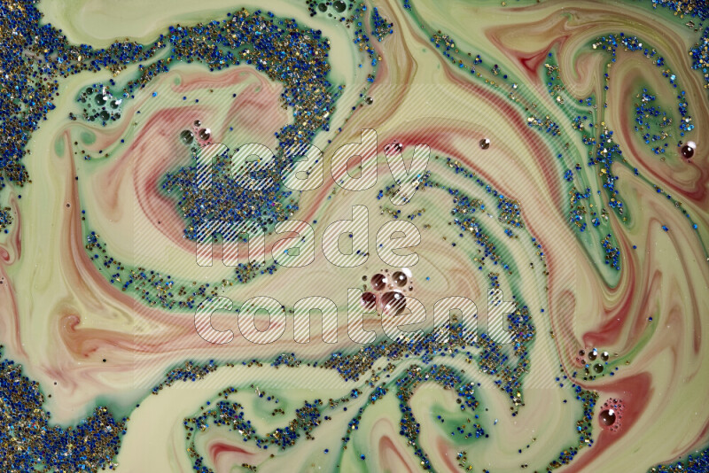 لقطة مقربة لبريق أزرق وذهبي متلألئ منتشر على خلفية من اللون الأخضر والأحمر في حركات دائرية