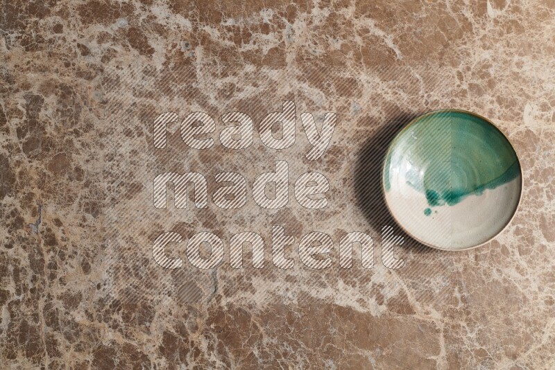 A decorative pottery plate on beige marble background