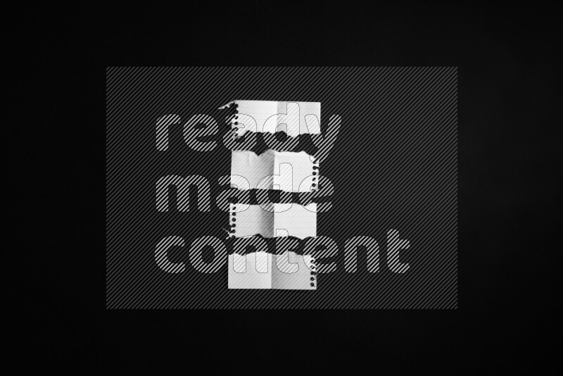 Ripped notebook sheet on black background