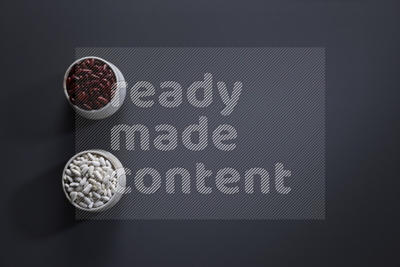 Legumes in pottery bowls on grey background