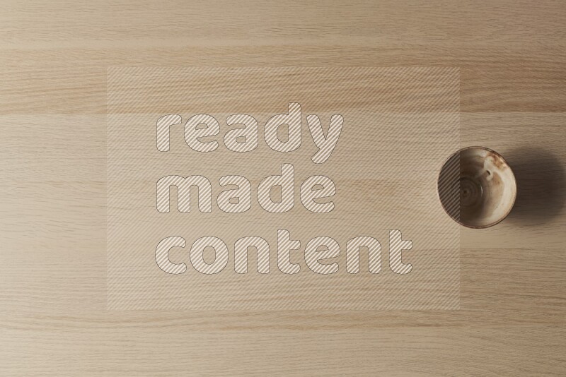 A beige pottery bowl on light wooden background