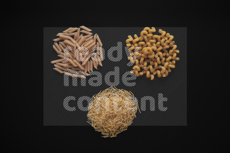 Different pasta types in bunches on black background