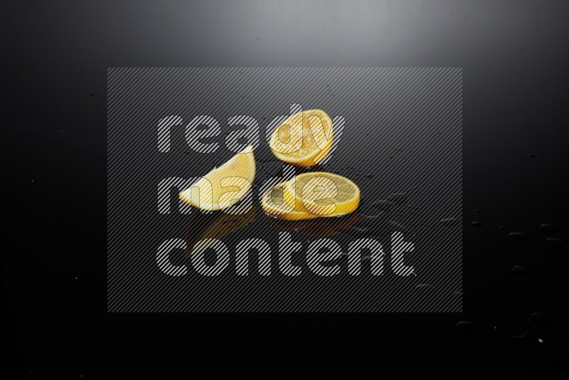 Lemon slices with water drops, and droplets on black background