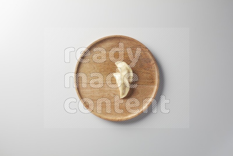 Two Sambosas on a wooden round plate on a white background