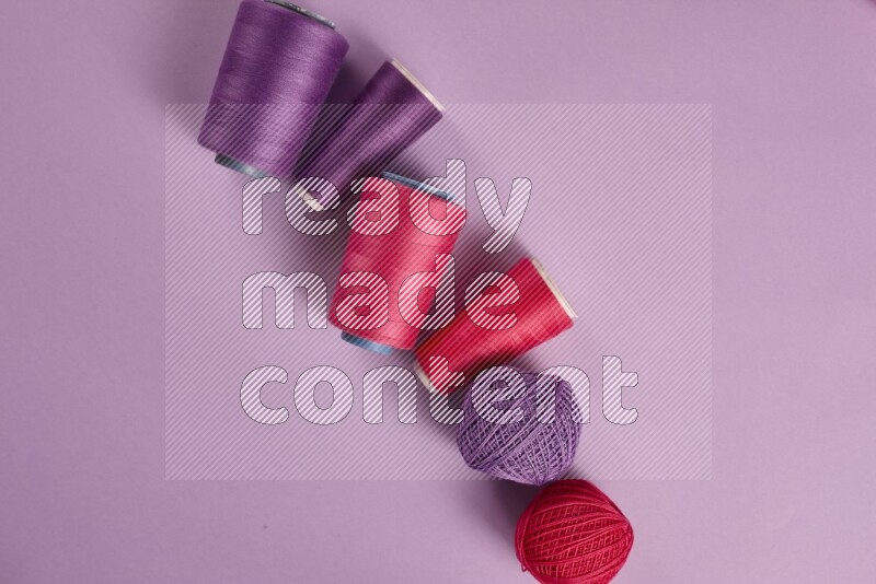 A pink and purple collection of sewing and tailoring tools arranged on a purple background
