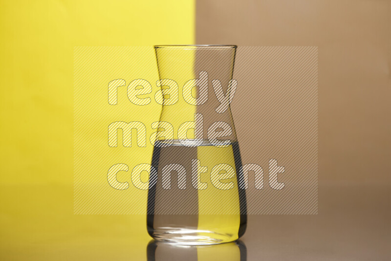 The image features a clear glassware filled with water, set against yellow and beige background