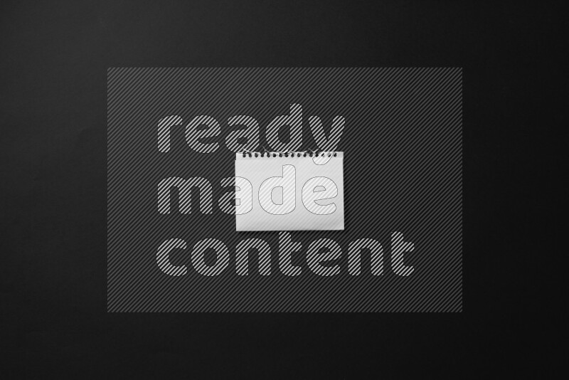 Folded notebook sheet on black background