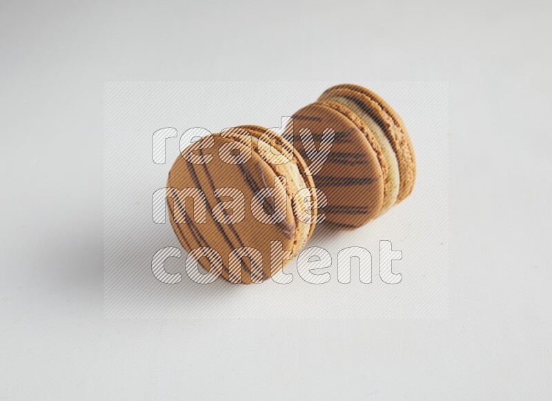 45º Shot of two light brown  Almond Cream macarons on white background