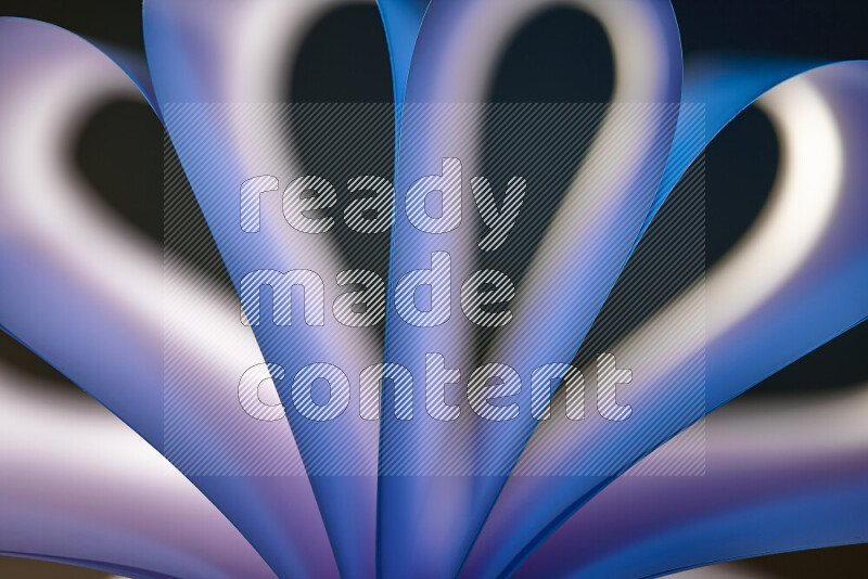 An abstract art piece displaying smooth curves in white and blue gradients created by colored light