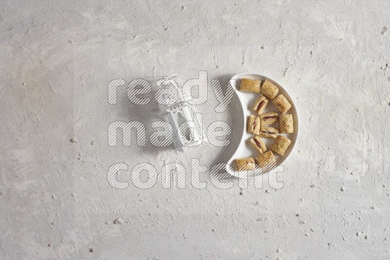 حلويات شرقية في صحن فخاري مع فانوس معدني