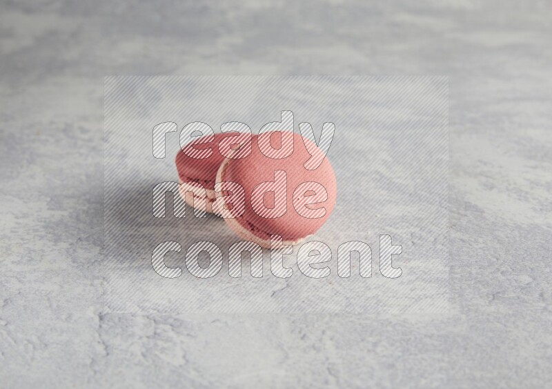 45º Shot of two Pink Litchi Raspberry macarons  on white  marble background