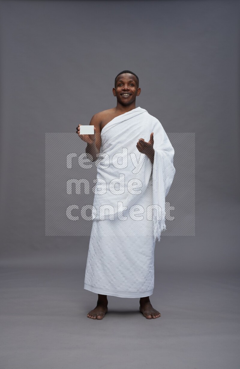 A man wearing Ehram Standing holding ATM card on gray background