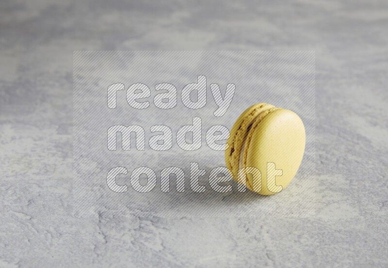 45º Shot of Yellow Lime macaron on white marble