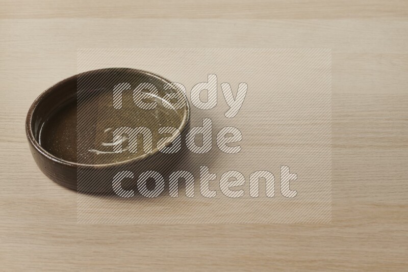 A multicolored pottery oven plate on light wooden background